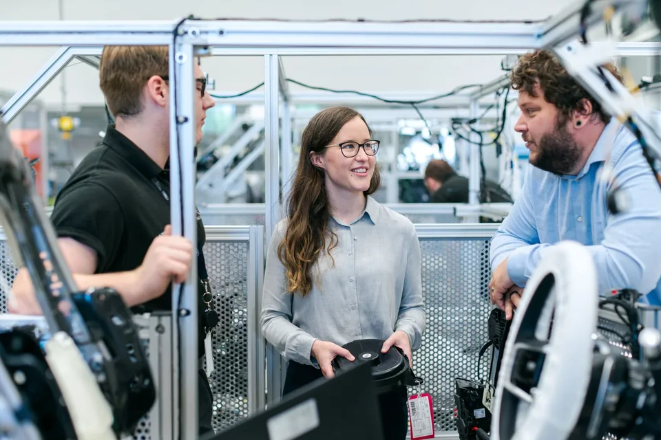 Technische medewerkers bespreken een project samen in de werkplaats